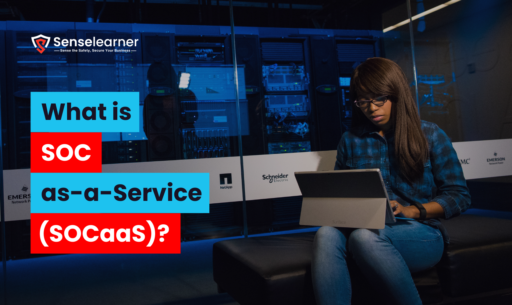 An image with the Senselearner logo above that reads, "What is SOC as-a-Service (SOCaaS)?" is displayed next to a woman using a Microsoft Surface device in a server room.